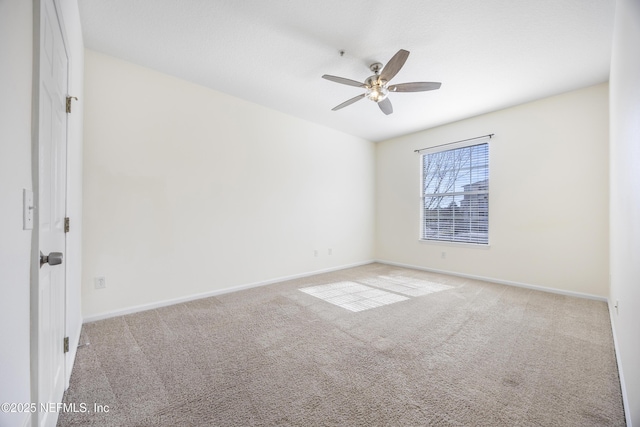 carpeted spare room featuring ceiling fan