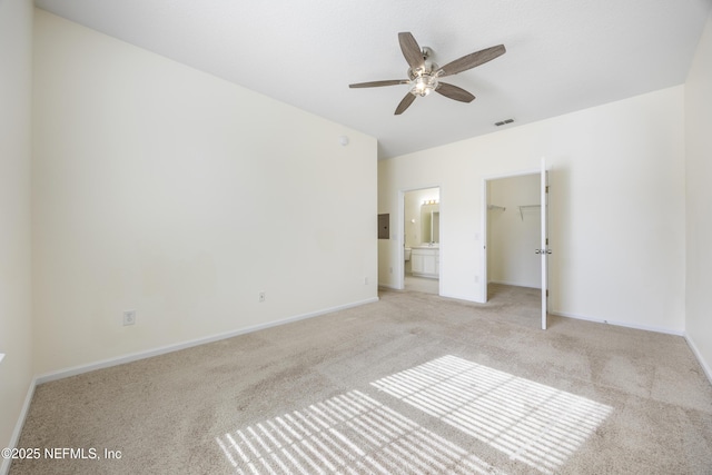 unfurnished bedroom with ensuite bathroom, light colored carpet, ceiling fan, a spacious closet, and a closet