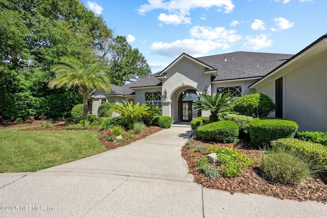 view of front of home with a front yard and french doors