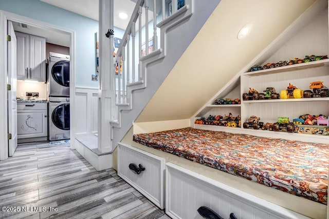 interior space with stacked washer and dryer and light hardwood / wood-style flooring