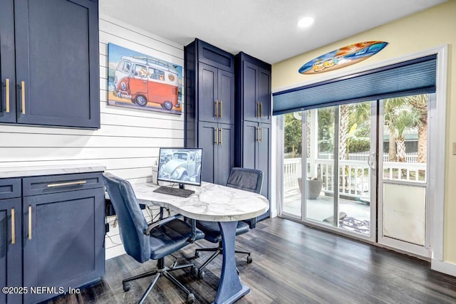 home office featuring dark hardwood / wood-style floors and wood walls