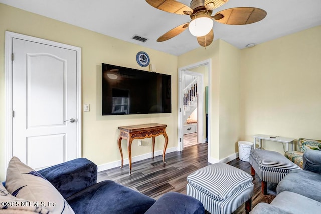 living room featuring ceiling fan and dark hardwood / wood-style flooring