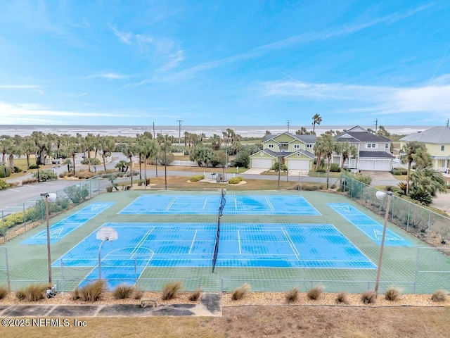 view of tennis court featuring a water view