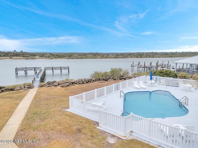 view of swimming pool featuring a water view and a yard