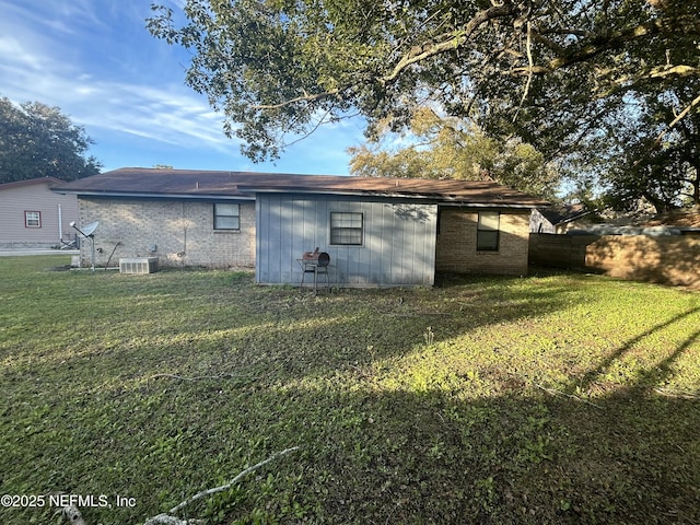 rear view of property featuring a lawn