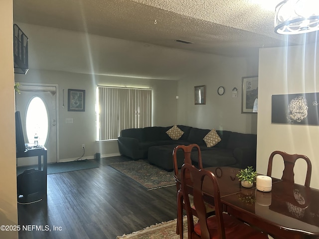 dining space featuring a textured ceiling and dark hardwood / wood-style flooring