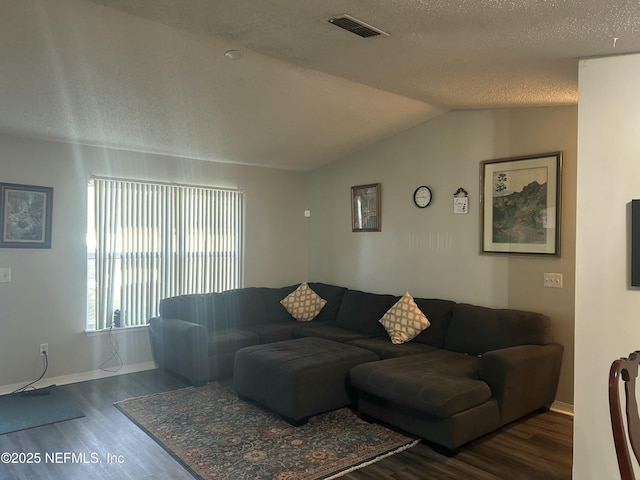 living room with vaulted ceiling, dark hardwood / wood-style floors, and a textured ceiling