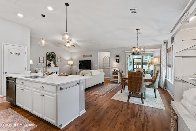 kitchen with ceiling fan with notable chandelier, white cabinetry, an island with sink, sink, and stainless steel dishwasher