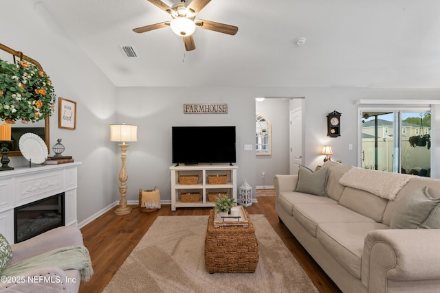 living room featuring ceiling fan, dark wood-type flooring, and lofted ceiling