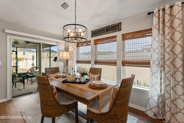 dining area featuring hardwood / wood-style floors and a notable chandelier