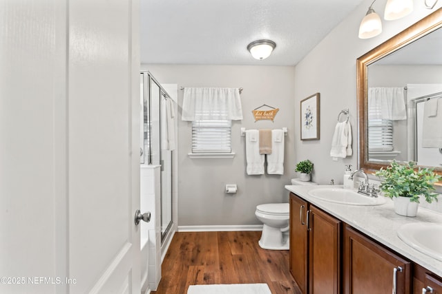 bathroom with a shower with shower door, vanity, a textured ceiling, and hardwood / wood-style flooring