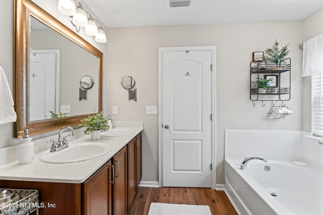 bathroom featuring a bath, hardwood / wood-style floors, and vanity