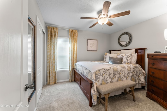 carpeted bedroom featuring a textured ceiling and ceiling fan