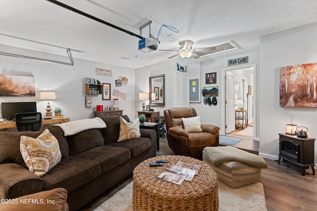 living room with a textured ceiling, electric panel, and hardwood / wood-style floors