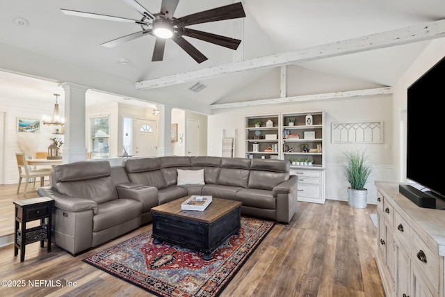 living room featuring decorative columns, dark hardwood / wood-style floors, lofted ceiling with beams, built in shelves, and ceiling fan with notable chandelier