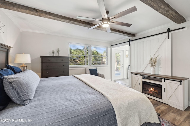 bedroom featuring crown molding, ceiling fan, hardwood / wood-style floors, access to outside, and a barn door