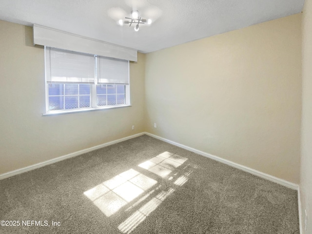 unfurnished room featuring carpet floors and a notable chandelier