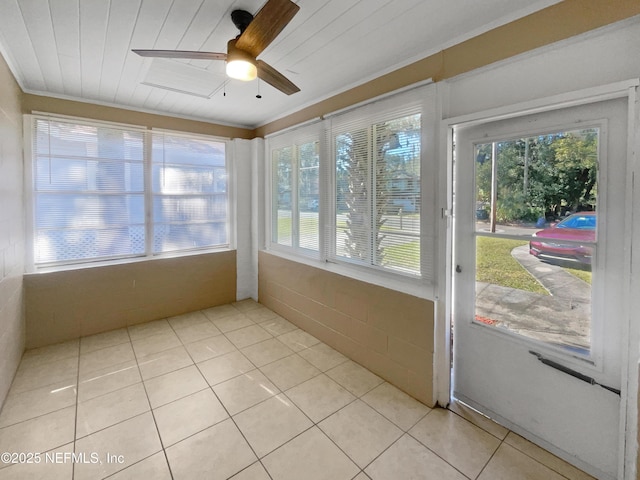 unfurnished sunroom with ceiling fan, a wealth of natural light, and wooden ceiling