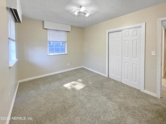 unfurnished bedroom featuring carpet, a closet, and a textured ceiling