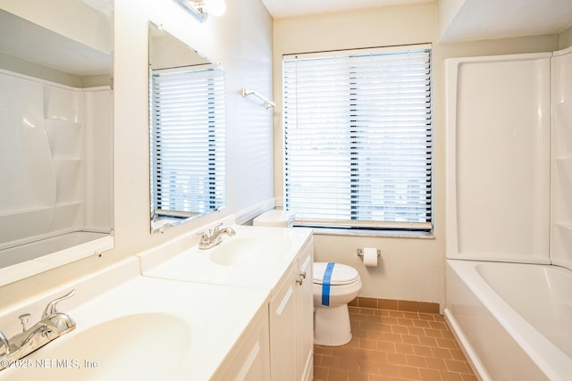 full bathroom featuring plenty of natural light, toilet, tile patterned flooring, and vanity