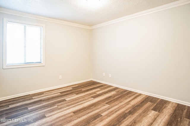 spare room featuring crown molding, wood-type flooring, and a textured ceiling