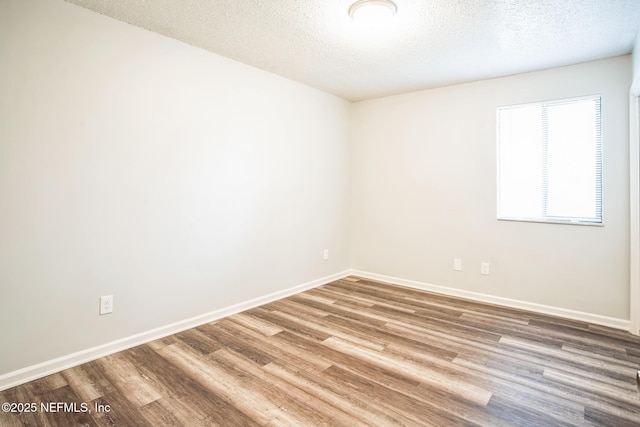 spare room featuring hardwood / wood-style floors and a textured ceiling