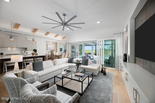 living room with ceiling fan, sink, and light hardwood / wood-style flooring