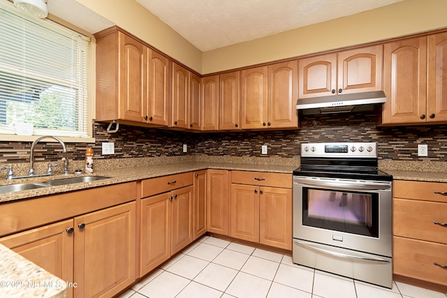 kitchen featuring light stone countertops, electric stove, backsplash, sink, and light tile patterned floors