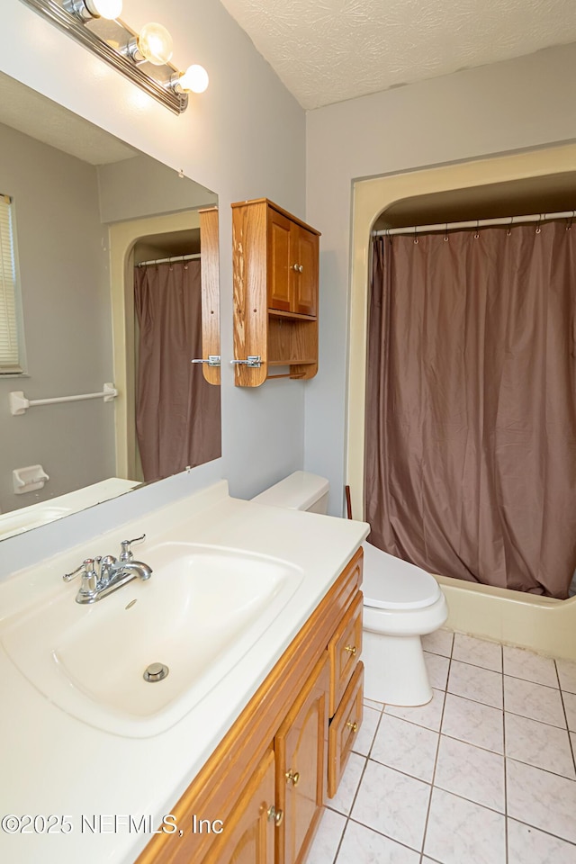 bathroom featuring a textured ceiling, toilet, tile patterned floors, and vanity