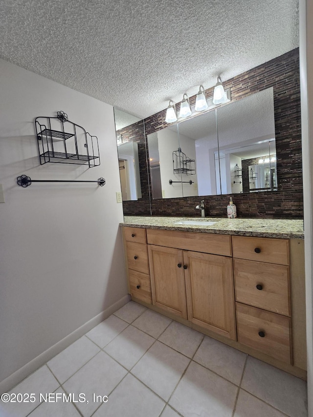 bathroom with vanity, backsplash, tile patterned floors, and a textured ceiling