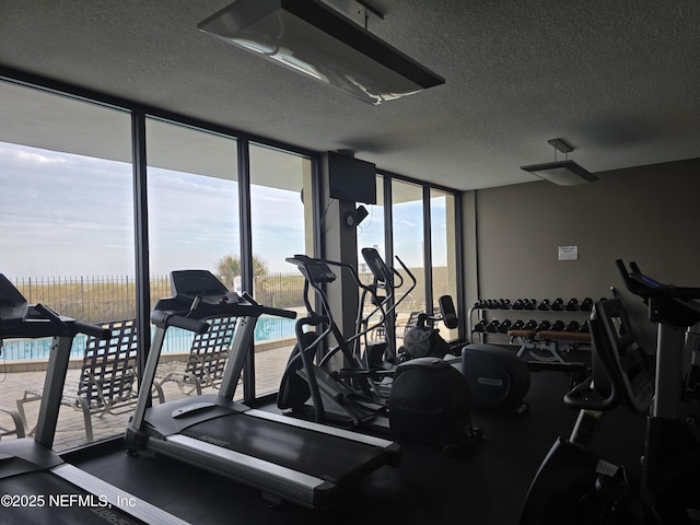 workout area featuring expansive windows and a textured ceiling