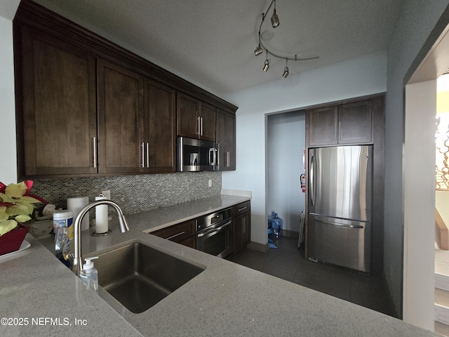 kitchen featuring light stone countertops, appliances with stainless steel finishes, sink, and dark brown cabinets