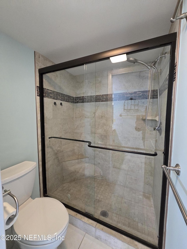 full bathroom with toilet, a stall shower, and tile patterned floors