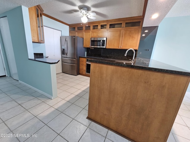 kitchen with glass insert cabinets, stainless steel appliances, decorative backsplash, and light tile patterned flooring