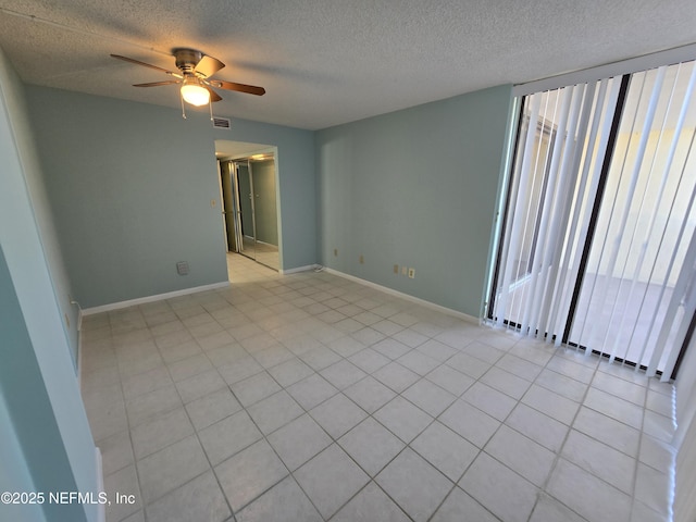 spare room with ceiling fan, a textured ceiling, visible vents, and baseboards