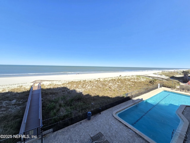 property view of water with a view of the beach and fence