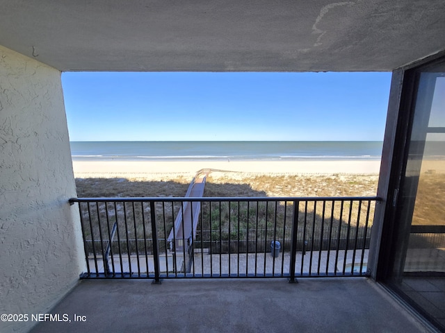 balcony with a water view and a beach view