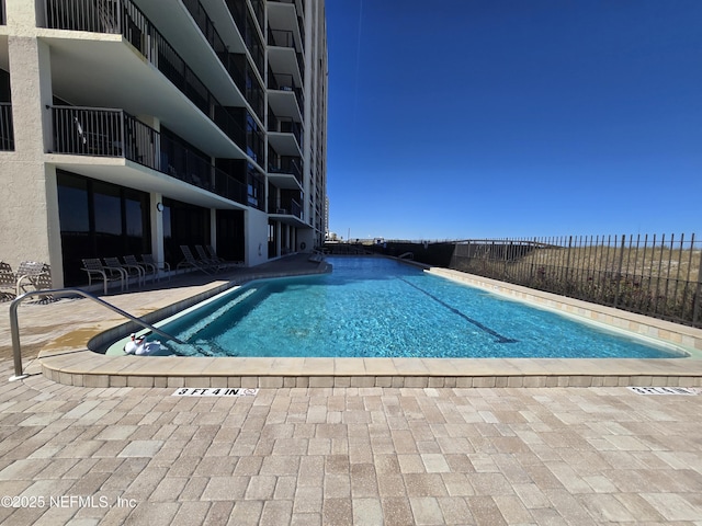 community pool featuring a patio area and fence