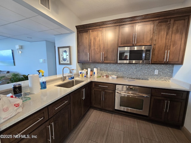 kitchen featuring visible vents, appliances with stainless steel finishes, backsplash, and a sink