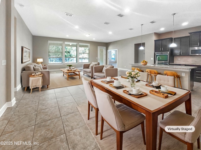 tiled dining area featuring a textured ceiling and sink