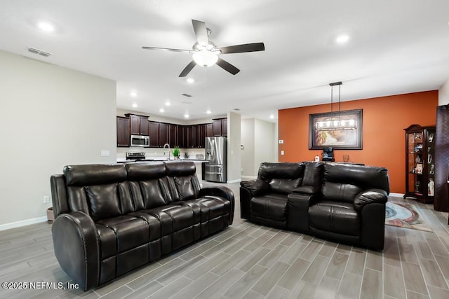 living room with ceiling fan and sink