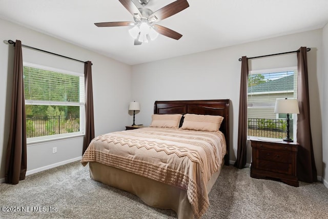 bedroom featuring ceiling fan, multiple windows, and carpet flooring