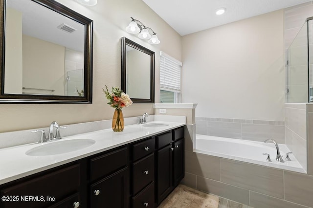 bathroom with a relaxing tiled tub and vanity