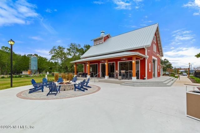 view of home's community featuring an outdoor fire pit and a patio