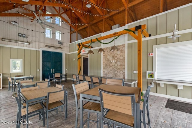 dining room featuring high vaulted ceiling, hardwood / wood-style floors, and ceiling fan