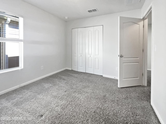 unfurnished bedroom featuring carpet and a closet