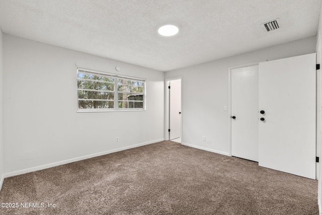 unfurnished bedroom with a textured ceiling and carpet floors