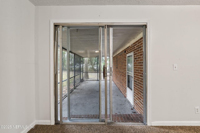 hall with a textured ceiling and carpet floors