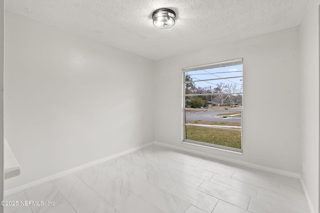 spare room with a textured ceiling