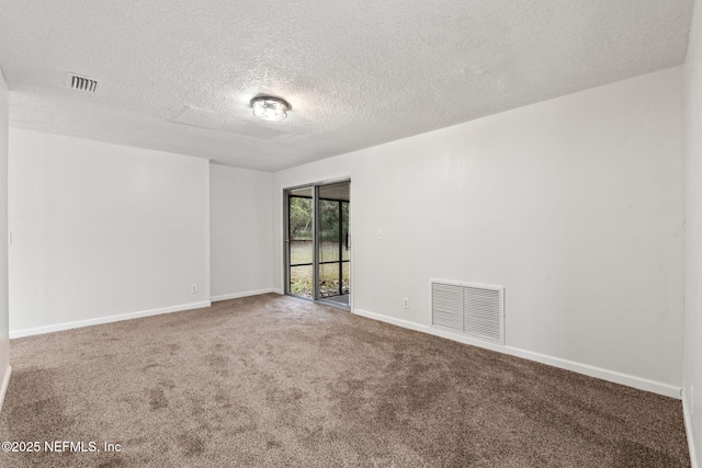 unfurnished room with carpet flooring and a textured ceiling